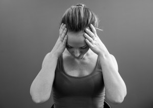 Kvinde tar seg til hodet, føler seg svimmel